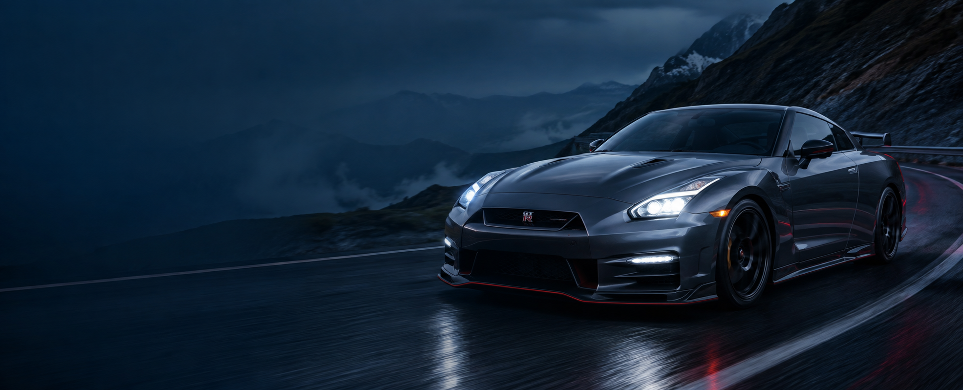 Nissan GT-R driving on a mountain road at dusk